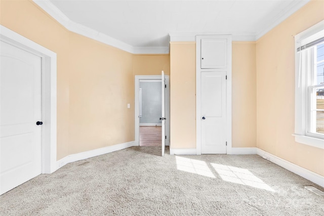 unfurnished bedroom featuring crown molding, multiple windows, and carpet