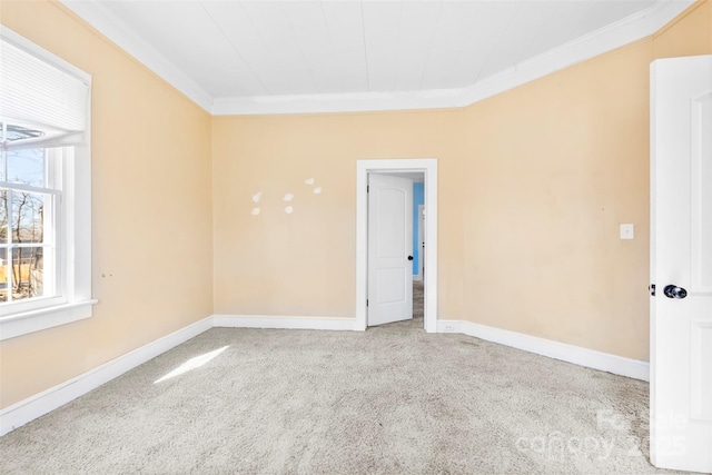 carpeted spare room featuring baseboards and ornamental molding