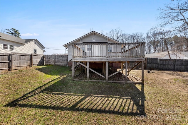 rear view of property with a wooden deck, a lawn, and a fenced backyard