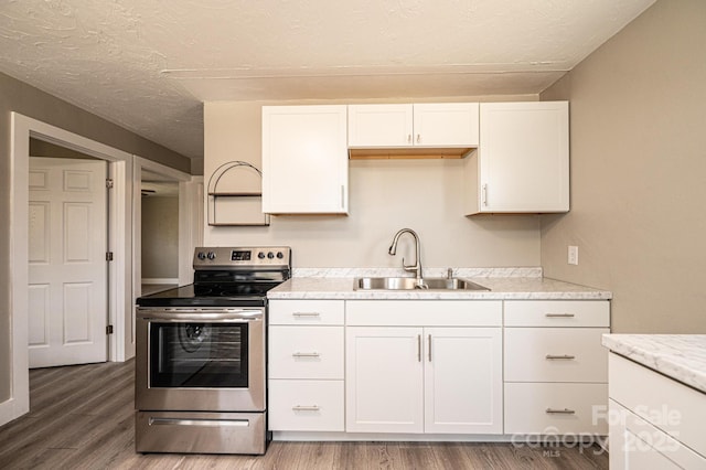 kitchen with white cabinets, light wood-style floors, a sink, and stainless steel electric range oven