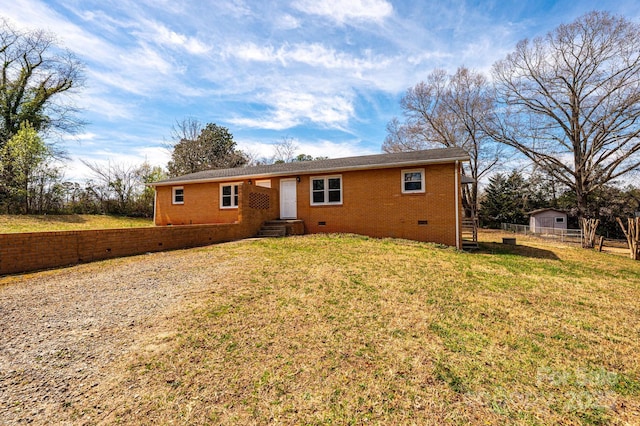 ranch-style house featuring brick siding, crawl space, fence, and a front lawn