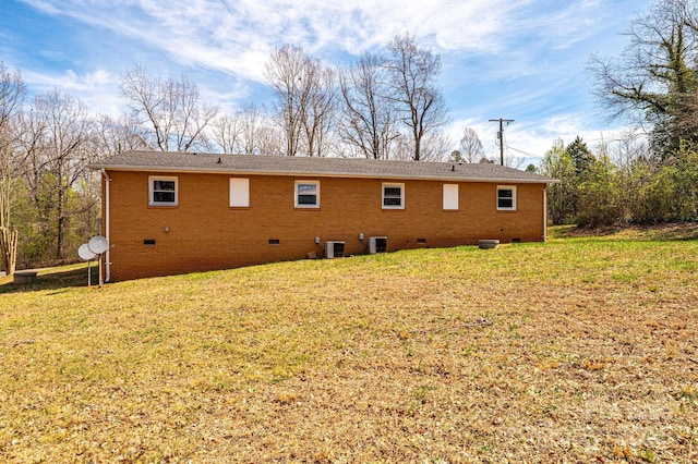 back of house featuring a lawn, central air condition unit, and crawl space