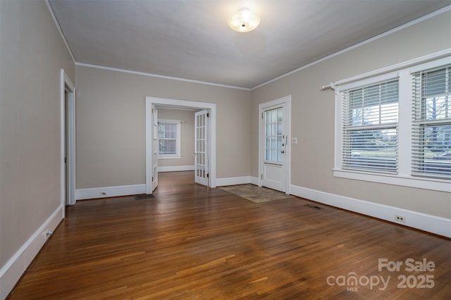 foyer with crown molding, wood finished floors, baseboards, and visible vents