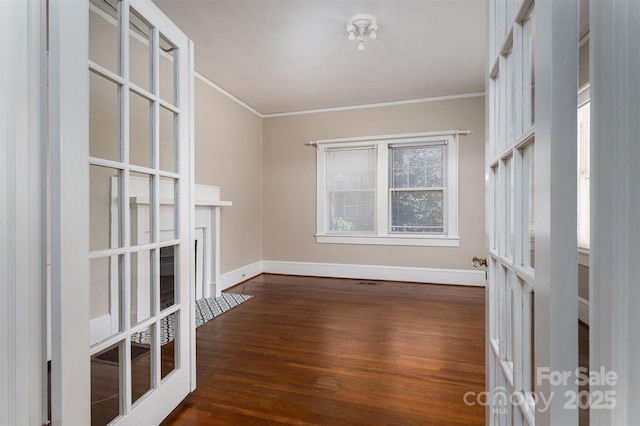 unfurnished room featuring dark wood finished floors, french doors, baseboards, and ornamental molding