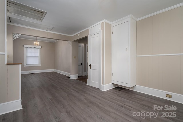 spare room featuring attic access, wood finished floors, baseboards, and ornamental molding