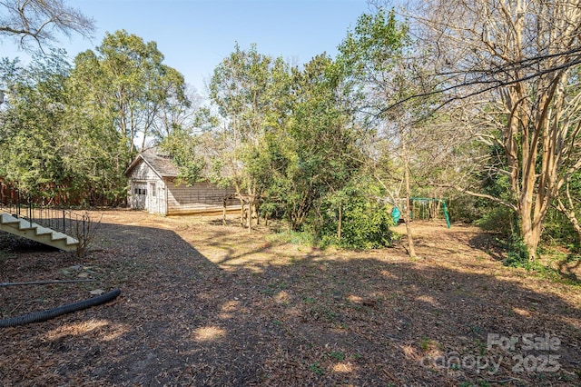 view of yard featuring a playground and an outdoor structure