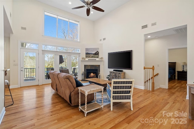 living area featuring visible vents, baseboards, recessed lighting, a fireplace, and light wood-type flooring