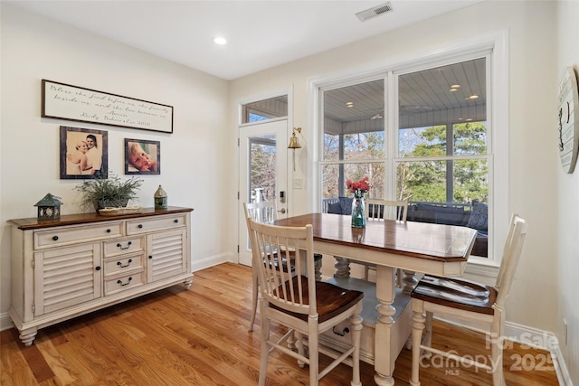 dining area with light wood-type flooring, visible vents, plenty of natural light, and baseboards