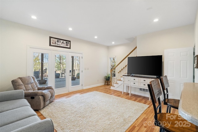 living area featuring light wood finished floors, baseboards, stairway, recessed lighting, and french doors