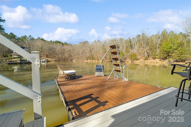 dock area featuring a forest view and a water view