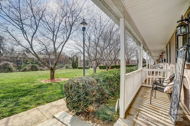 wooden deck with a lawn and a porch