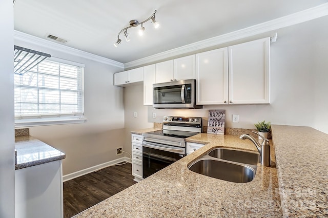 kitchen with visible vents, ornamental molding, a sink, appliances with stainless steel finishes, and light stone countertops