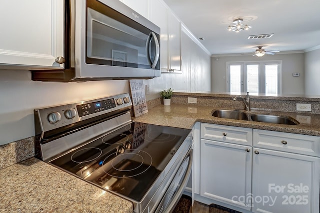kitchen featuring a sink, ornamental molding, visible vents, and stainless steel appliances