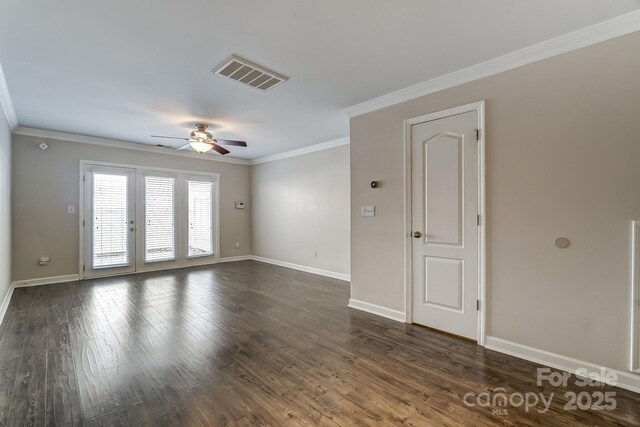 empty room featuring dark wood-style floors, visible vents, ceiling fan, and ornamental molding
