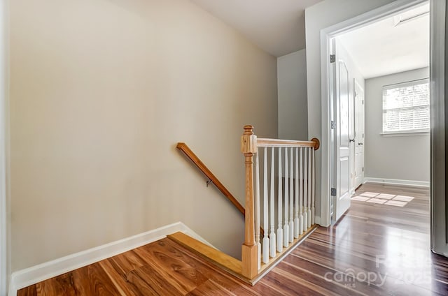 stairway featuring wood finished floors and baseboards