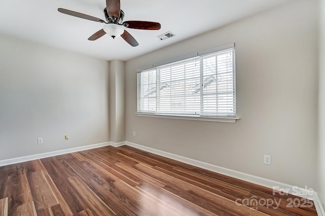 empty room with visible vents, baseboards, dark wood-type flooring, and ceiling fan