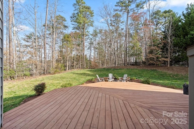 wooden deck featuring a lawn