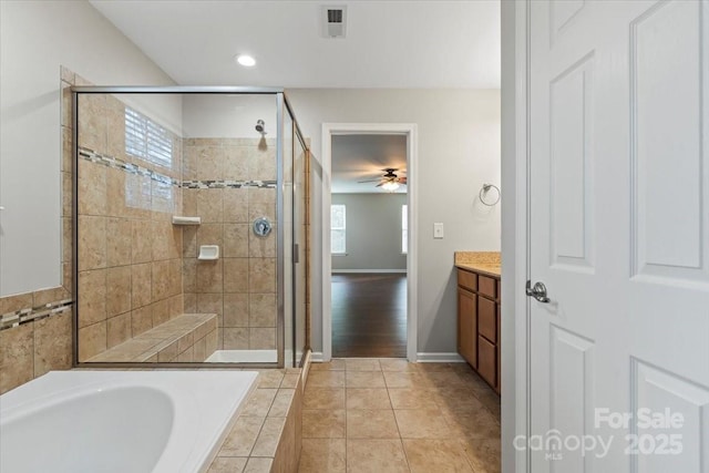 bathroom with tile patterned flooring, ceiling fan, a garden tub, a stall shower, and vanity