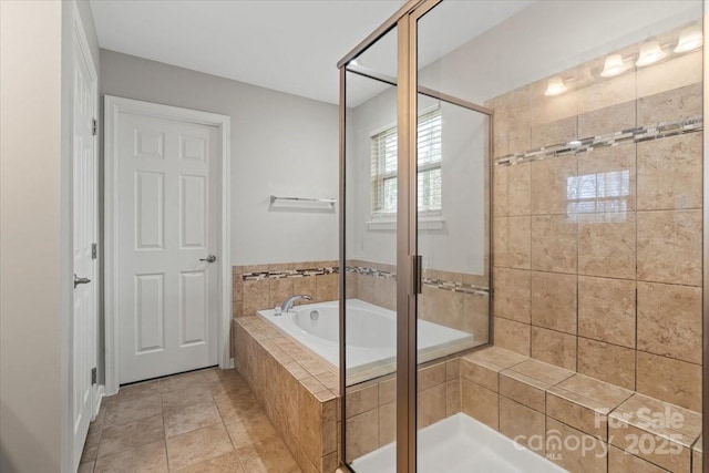 bathroom with tile patterned flooring, a bath, and a stall shower