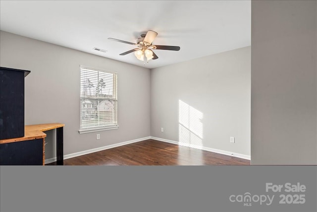 unfurnished living room with baseboards, a ceiling fan, and dark wood-style flooring