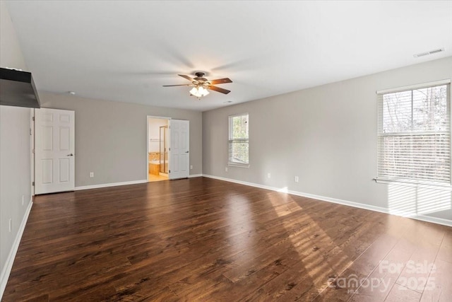 spare room with visible vents, baseboards, ceiling fan, and dark wood finished floors