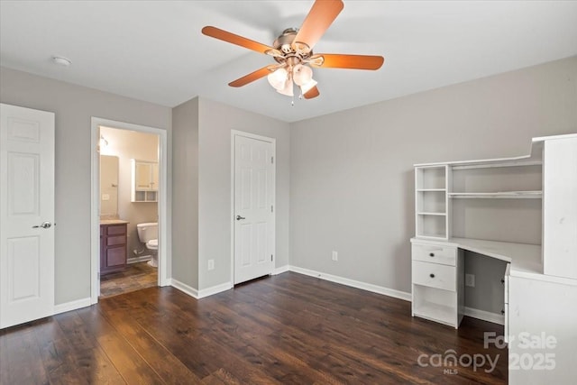 unfurnished bedroom with ceiling fan, baseboards, ensuite bath, and dark wood-style flooring