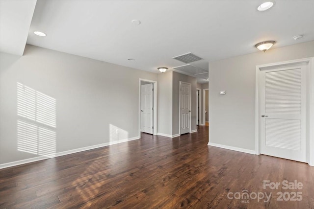 empty room featuring wood finished floors, visible vents, baseboards, attic access, and recessed lighting