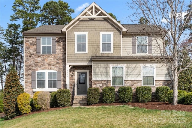 craftsman-style house featuring a front yard and stone siding