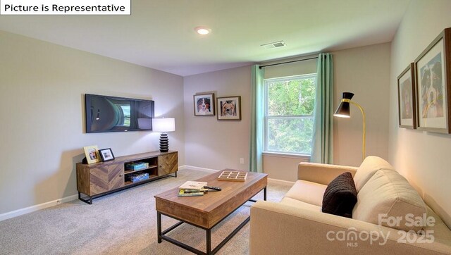 living room with visible vents, light colored carpet, and baseboards