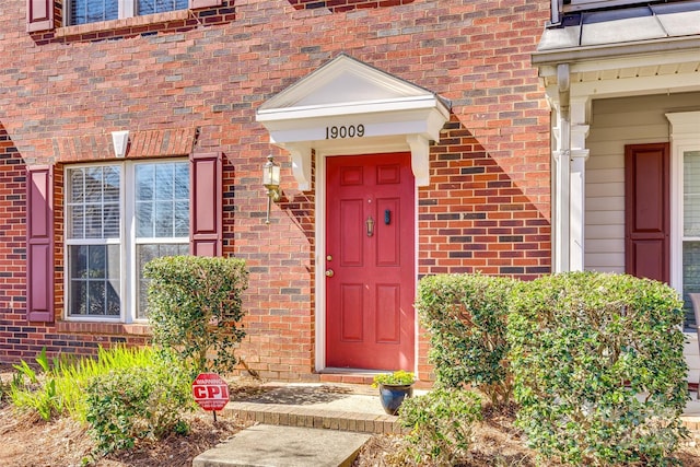 doorway to property featuring brick siding