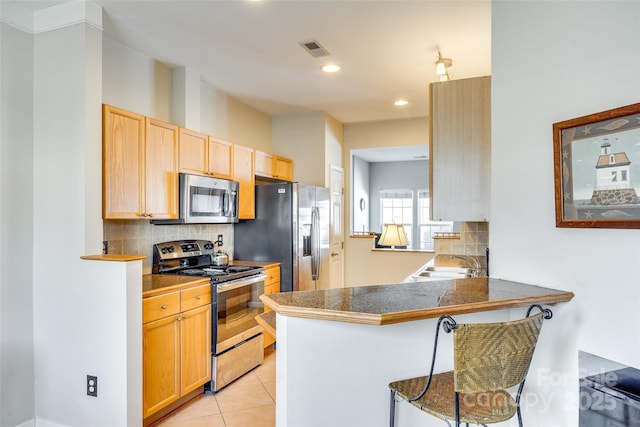 kitchen featuring a sink, decorative backsplash, visible vents, and stainless steel appliances