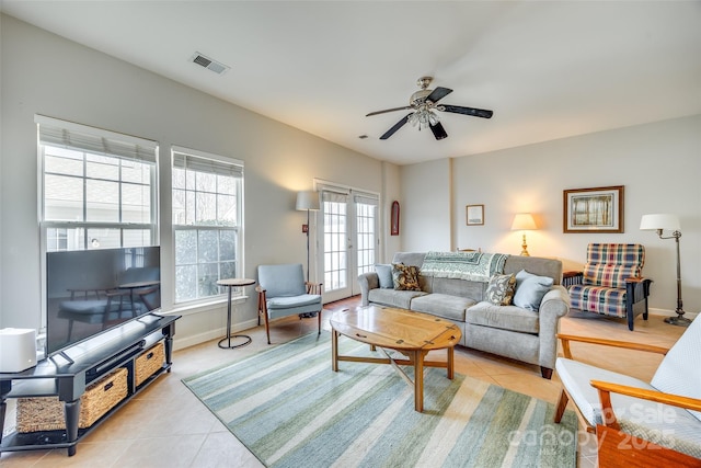 living area featuring light tile patterned floors, baseboards, visible vents, and ceiling fan