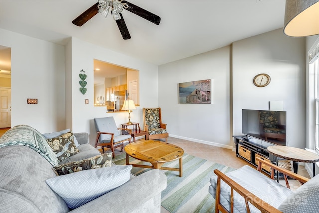 living area featuring baseboards, ceiling fan, and light tile patterned flooring