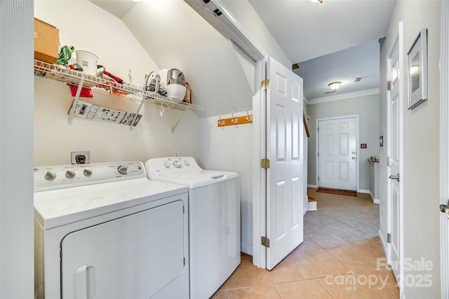 clothes washing area featuring baseboards, laundry area, light tile patterned flooring, ornamental molding, and independent washer and dryer