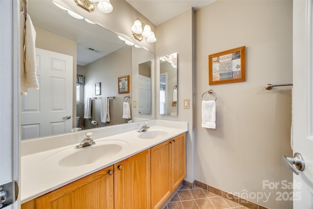 full bathroom with a sink, visible vents, double vanity, and tile patterned flooring