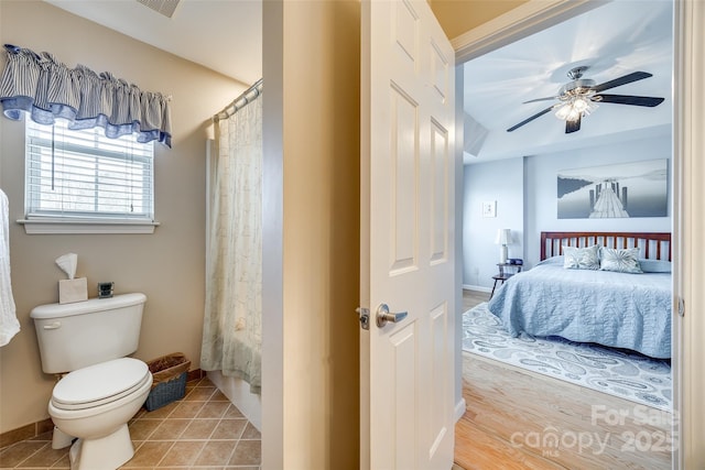 full bathroom featuring a ceiling fan, curtained shower, tile patterned floors, toilet, and connected bathroom