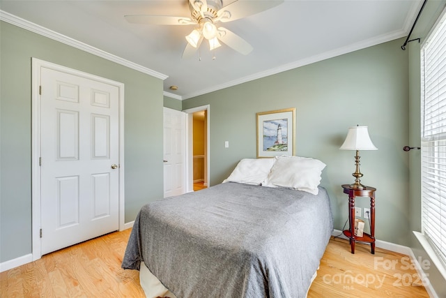 bedroom featuring light wood finished floors, a ceiling fan, crown molding, and baseboards