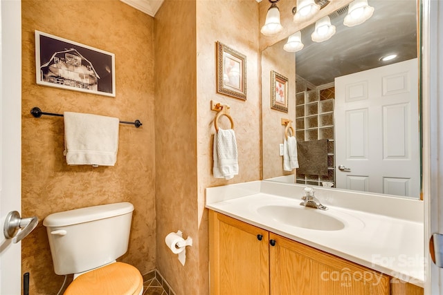 bathroom featuring toilet, vanity, and wallpapered walls