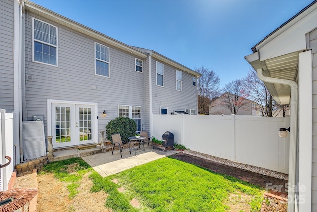 back of house featuring a patio area, french doors, fence, and a lawn