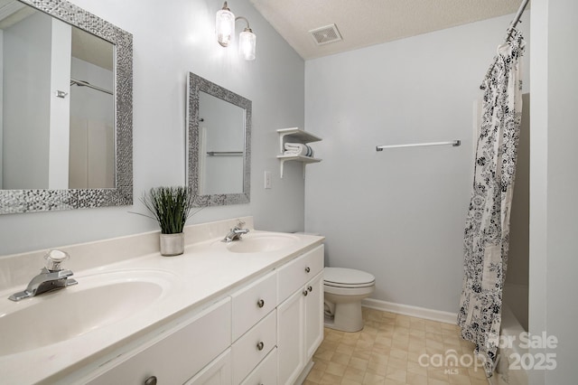 bathroom featuring double vanity, visible vents, toilet, and a sink