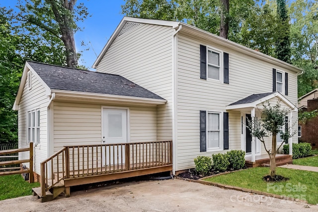 view of front facade featuring a deck and a shingled roof