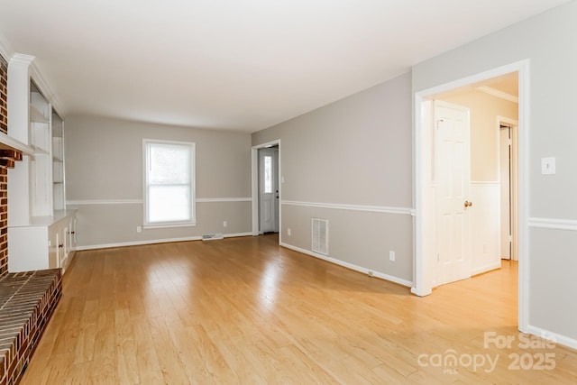 unfurnished living room with visible vents, baseboards, and light wood-style floors