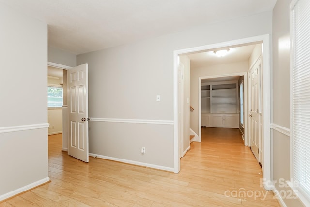 hall with baseboards and light wood-style flooring