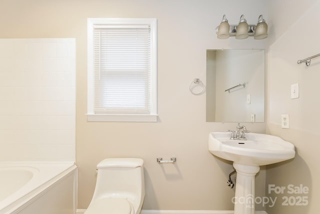 full bathroom with toilet and a tub to relax in