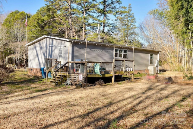 rear view of house featuring crawl space, a lawn, and a deck