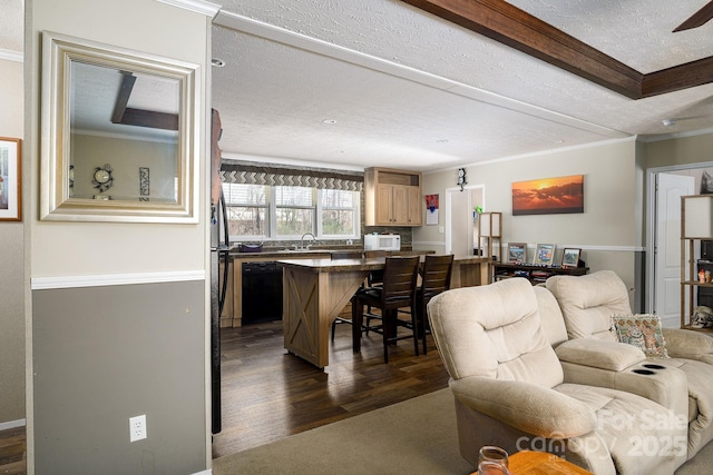 living area with dark wood finished floors, a textured ceiling, and ornamental molding