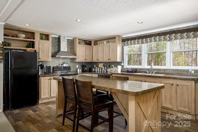 kitchen with black appliances, wall chimney exhaust hood, open shelves, and a sink