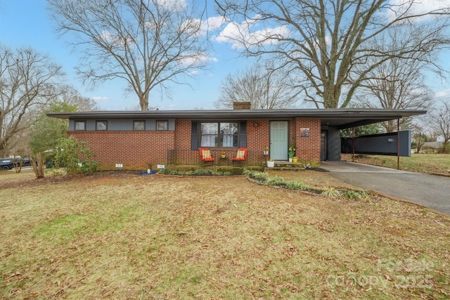 view of front of property with brick siding, a carport, a chimney, and driveway