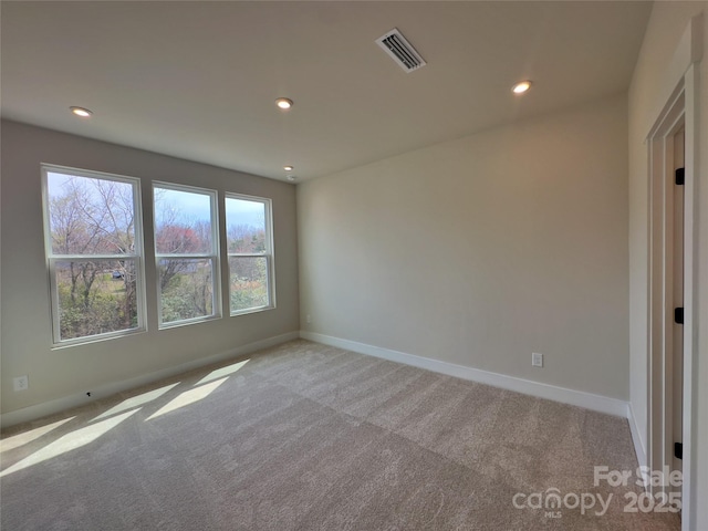 carpeted spare room featuring visible vents, recessed lighting, and baseboards