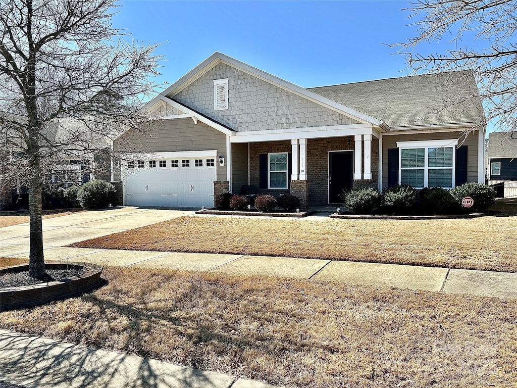 craftsman house featuring a front lawn, an attached garage, and driveway